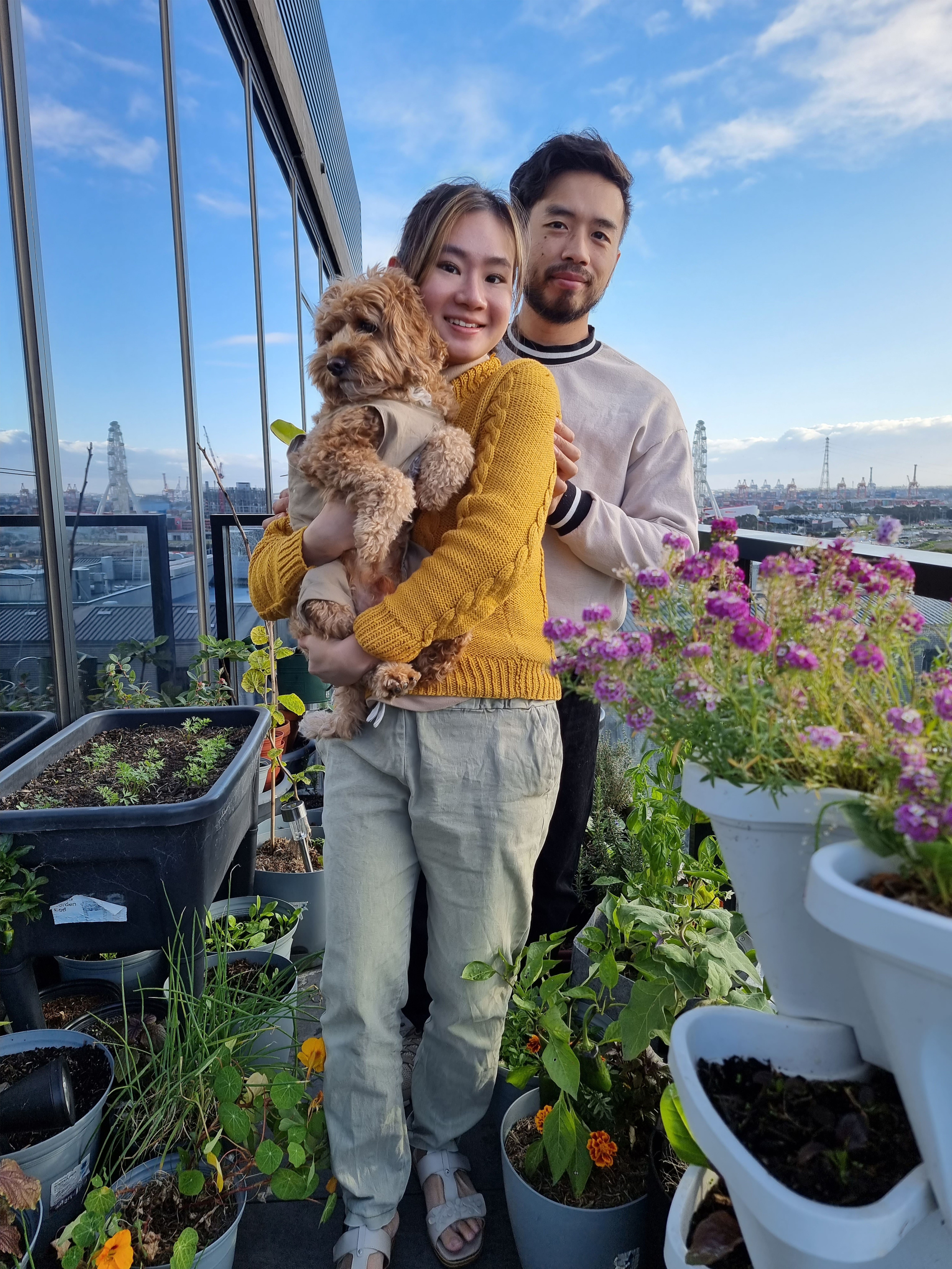 Cheng Yee与她的未婚夫和爱犬在阳台花园的植物旁边摆好拍照姿势。