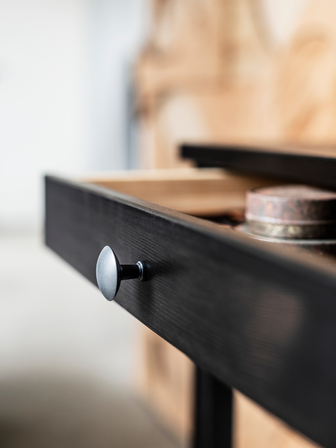 一张黑褐色的HEMNES 汉尼斯 办公桌,带两个抽屉,其中一个抽屉打开。